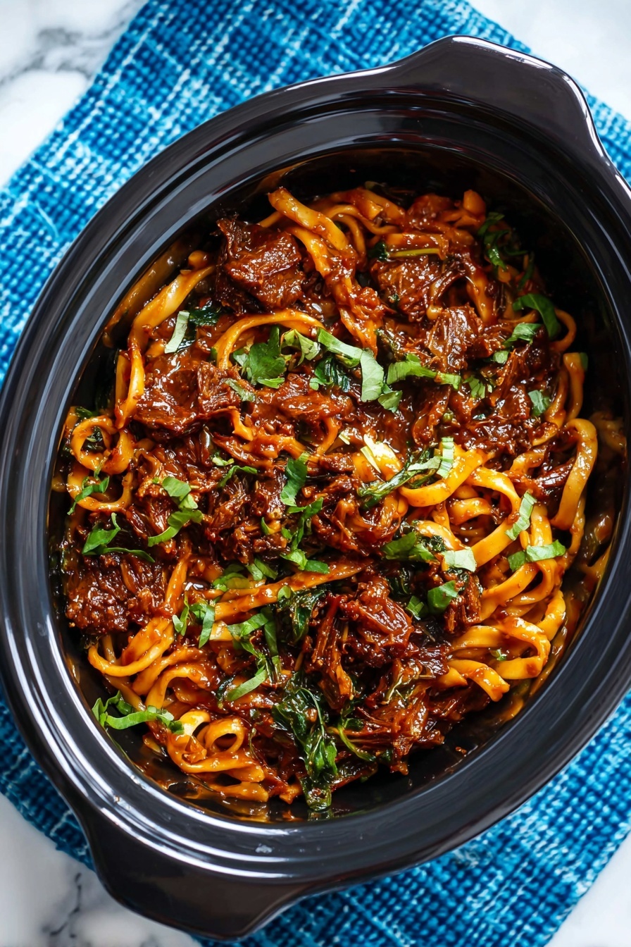 A white bowl filled with a rich, dark red-brown saucy dish that has visible pieces of shredded meat and slivers of orange carrots mixed in. Bright green sliced scallions are scattered on top, adding a fresh contrast. Small crunchy-looking bits, possibly nuts or fried shallots, are sprinkled over the dish. The bowl sits on a blue cloth with white stitched lines, and the background is a blurred red object on a white marbled surface. Photo taken with an iphone --ar 2:3 --v 7