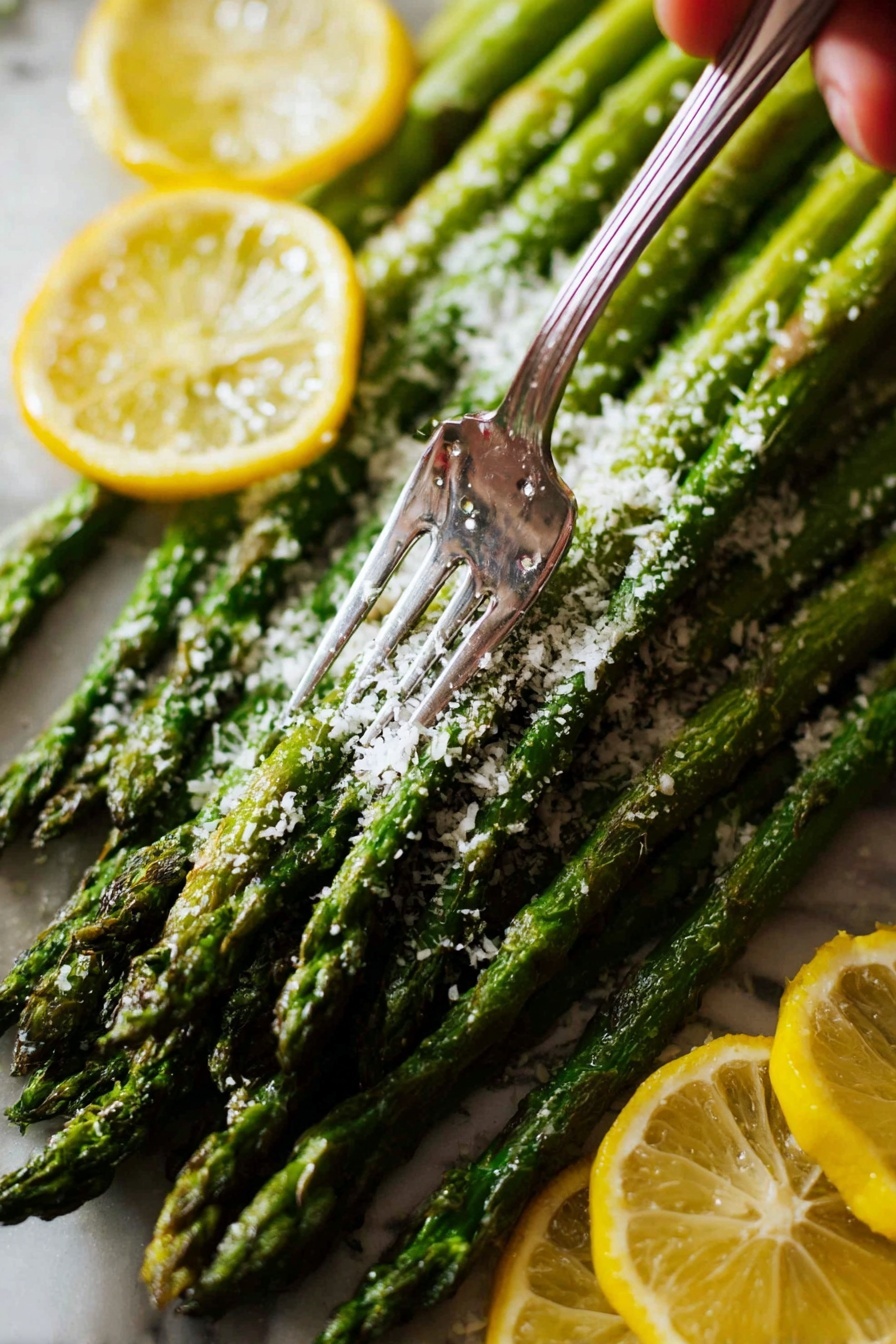 A bundle of bright green roasted asparagus spears lay together, topped with a sprinkling of grated white cheese that looks soft and fluffy. The asparagus stalks have a shiny, slightly wrinkled texture, showing they are cooked. A close-up view shows a fork piercing the asparagus from above, held by a woman's hand. Around the asparagus are thin slices of yellow lemon with visible seeds and juicy texture. The scene is set on a white marbled surface. photo taken with an iphone --ar 2:3 --v 7