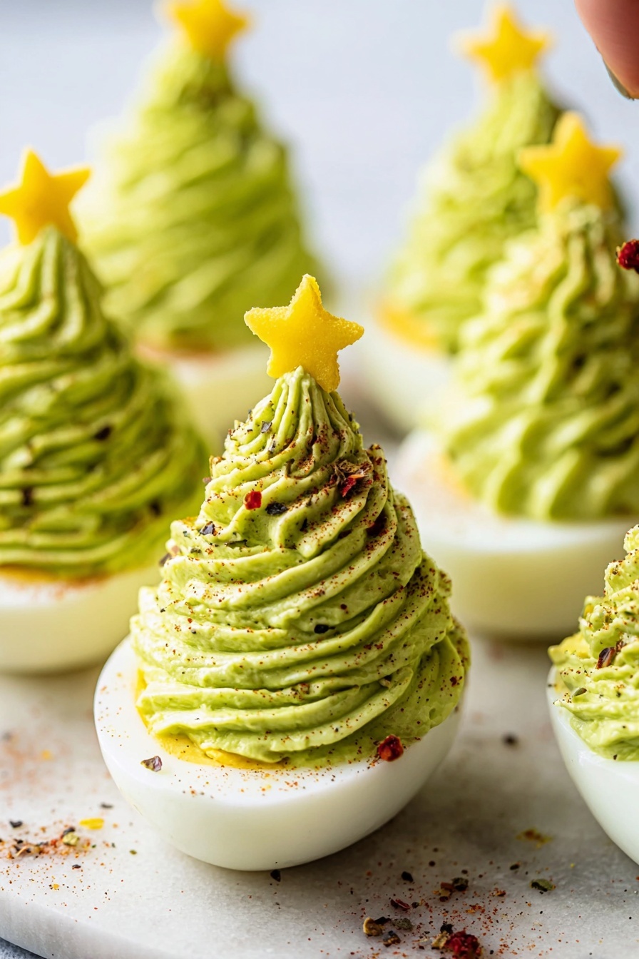 The image shows several halved boiled eggs placed on a white marbled surface, each topped with a tall swirl of bright green creamy mixture piped to look like a small Christmas tree. The green filling has a smooth, textured appearance with fine ridges from the piping. One egg is topped with a small yellow star-shaped slice, resembling a tree topper. The green swirls are sprinkled evenly with small bits of red and black seasoning, adding color contrast. The eggs are arranged close together, and the photo focuses closely on the front eggs with a soft, blurred background. Photo taken with an iphone --ar 2:3 --v 7