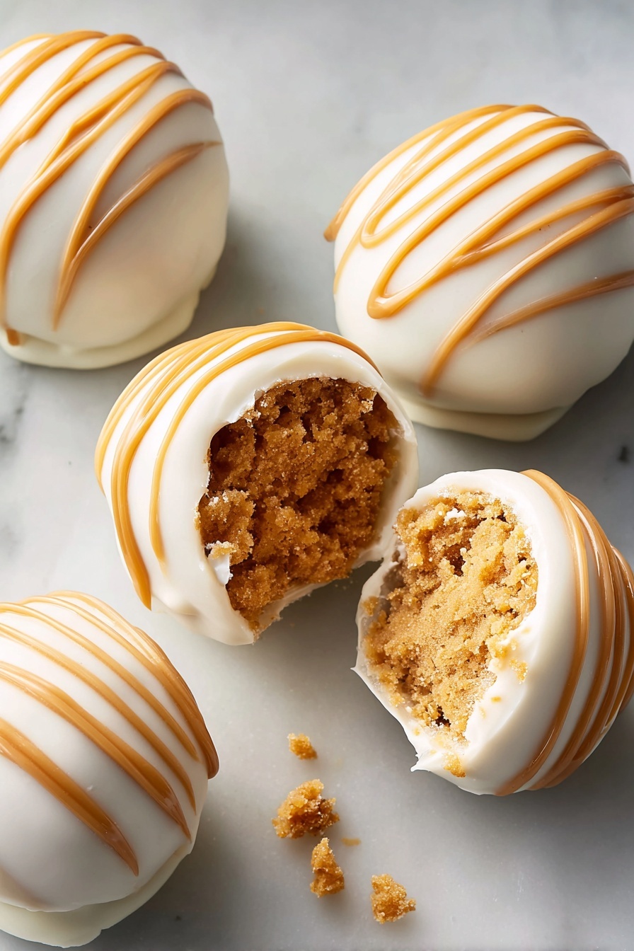 Round truffles covered in smooth white chocolate form the top layer, decorated with evenly spaced caramel brown stripes drizzled diagonally across each piece. One truffle in the center is partially open, showing a thick, crumbly light brown peanut butter filling inside, with some white chocolate shell bits around it. The truffles are placed closely together on a white marbled surface, filling the frame evenly. The lighting highlights their shiny texture and the contrast between the creamy white shell and rich caramel stripes. photo taken with an iphone --ar 2:3 --v 7