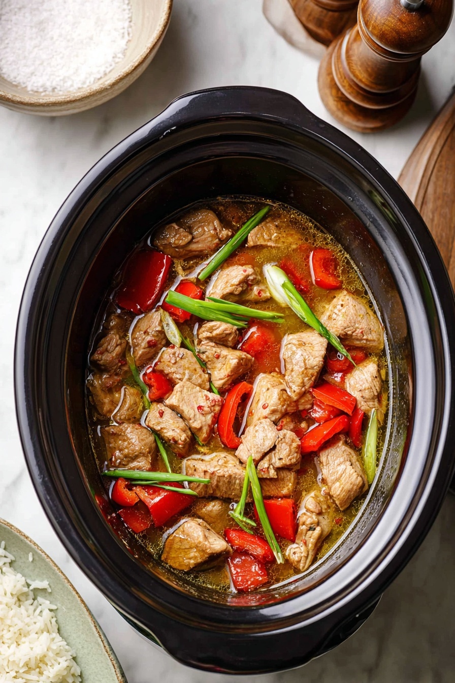 A black slow cooker filled with a stew made of multiple chunks of light brown meat layered with red bell pepper pieces and green spring onion stalks, all in a light brown broth that fills the pot partially. The slow cooker sits on a white marbled surface with a wooden pepper grinder and a round bowl of salt visible in the top part of the image, and a white plate of cooked rice partly visible at the bottom left corner. Photo taken with an iphone --ar 2:3 --v 7