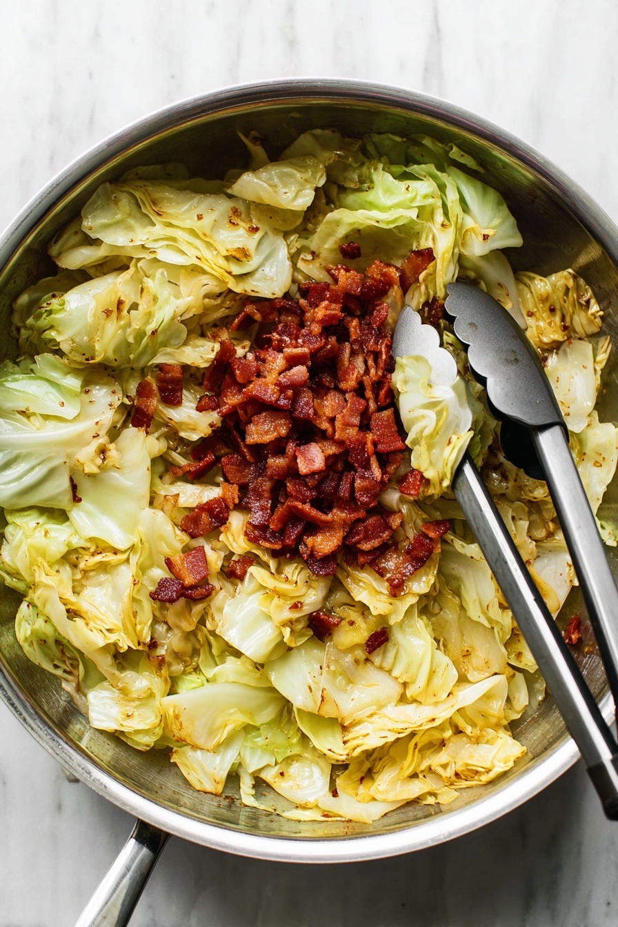 A close-up view of cooked cabbage mixed with small pieces of browned bacon in a metal pan. The dish has layers of chopped light green cabbage with soft, slightly translucent texture and crispy, dark reddish-brown bacon bits scattered evenly on top and throughout. The pan beneath the food is blurred but shows more cabbage and bacon. The lighting highlights the shiny, slightly oily surface of the cabbage and the crisp edges of the bacon. photo taken with an iphone --ar 2:3 --v 7