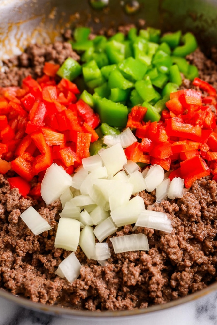 A white bowl filled with a layered cheesy casserole showing creamy white sauce, browned ground meat pieces, melted orange and white cheese layers with some green and red bell peppers mixed in, and slices of yellow cooked potatoes visible underneath; a silver spoon scoops some of the cheesy mix from the bowl resting on a white marbled surface with a striped cloth nearby. Photo taken with an iphone --ar 2:3 --v 7