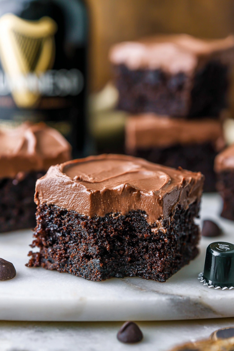 A clear glass bowl holds a thick, smooth dark brown chocolate mixture with a shiny surface. Inside the bowl, a silver whisk with thin metal wires is coated in the chocolate, resting in the center. The bowl sits on a white marbled surface that contrasts with the rich chocolate color, and the outer edge of the bowl reflects some soft light. photo taken with an iphone --ar 2:3 --v 7