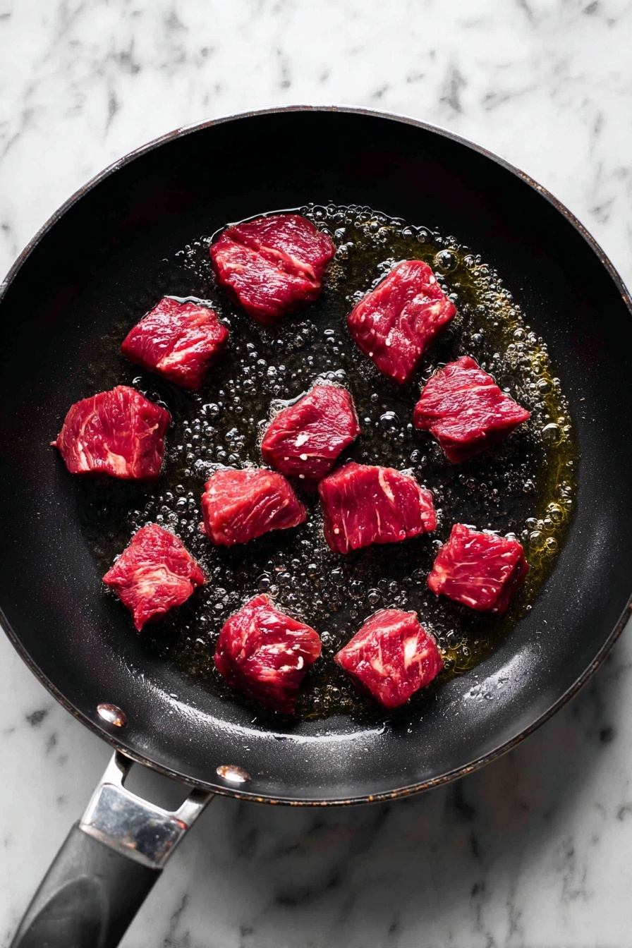 A white bowl filled with three layers: the bottom layer is smooth creamy mashed potatoes in white color, the middle layer consists of large chunks of dark brown tender meat with visible strands, scattered bright orange carrot slices, and light green celery pieces, all covered in thick, shiny rich brown gravy sauce with a slightly chunky texture; a silver spoon lifts some meat with strands falling apart, and small green herb pieces garnish the top. The bowl sits on a white marbled surface. Photo taken with an iphone --ar 2:3 --v 7
